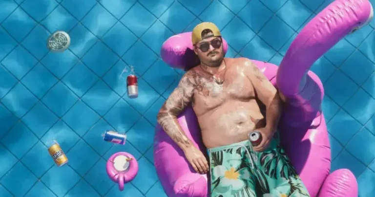 GTA 6 Trailer 2 screenshot of a tattooed guy floating on a pink flamingo pool float in a bright blue pool with cans drifting around