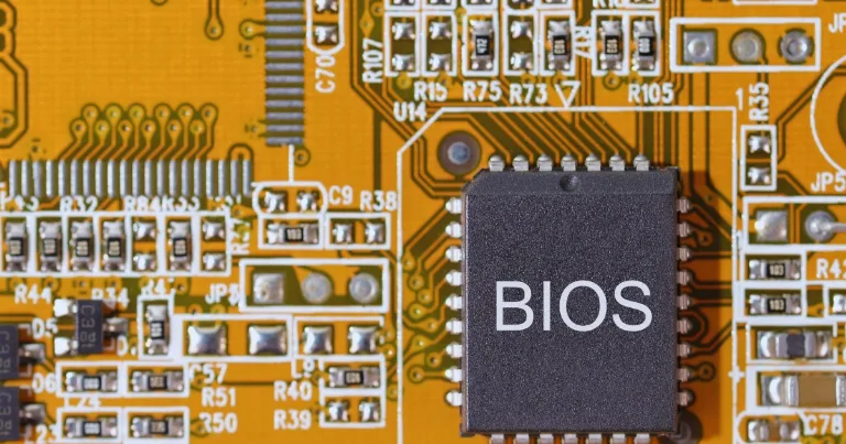 BIOS chip close up on orange motherboard with circuits