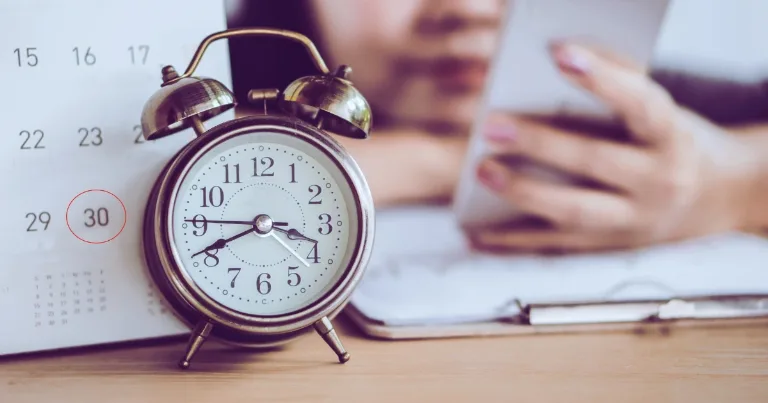 alarm clock with calendar and phone procrastination concept