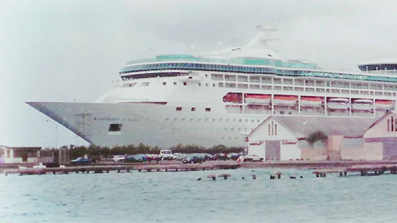 Rhapsody of the Seas Rhapsody of the Seas docked at port, viewed from the shoreline on a cloudy day.