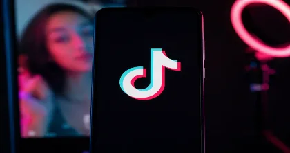 TikTok logo on smartphone representing Creator Rewards drops and originality review